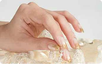 women showing her gold nail in golden dress